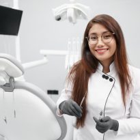 Dentist keeping dental tools and smiling in clinic