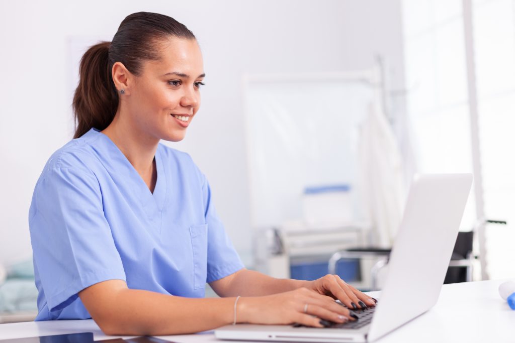 Medical nurse in uniform using laptop