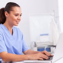 Medical nurse in uniform using laptop