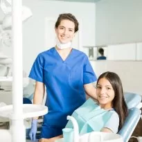 Portrait Of Smiling Dentist And Teenage Girl In Clinic